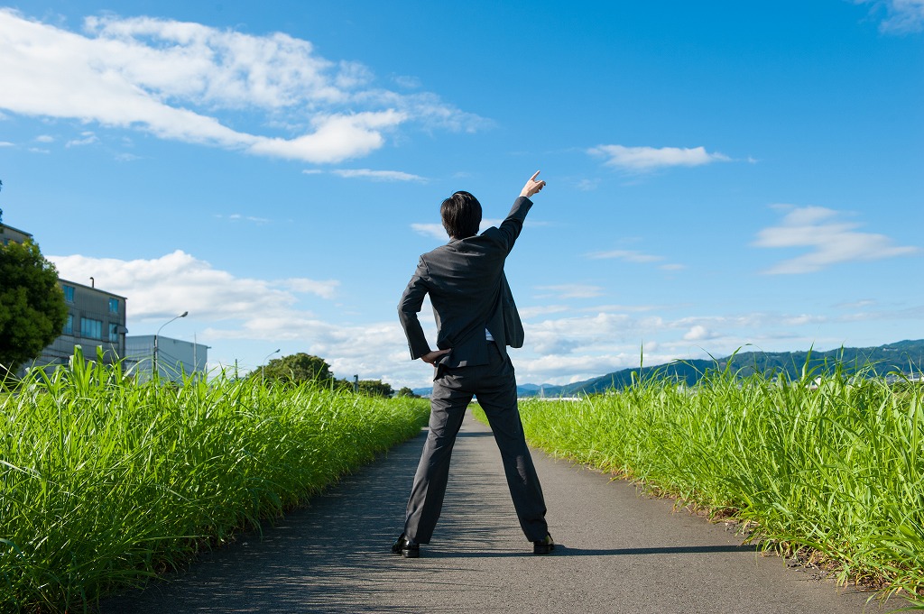 空を指さす男性
